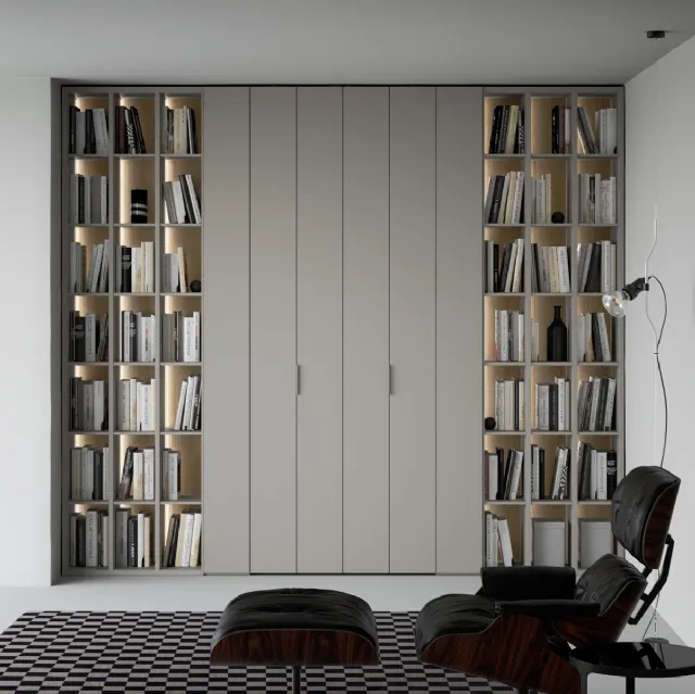 Libreria a giorno lineare e geometrica, in laccato opaco, arricchita dalla schiena in laccato metallico Oxid e impreziosita dall’illuminazione a led passaggio porta di Caccaro